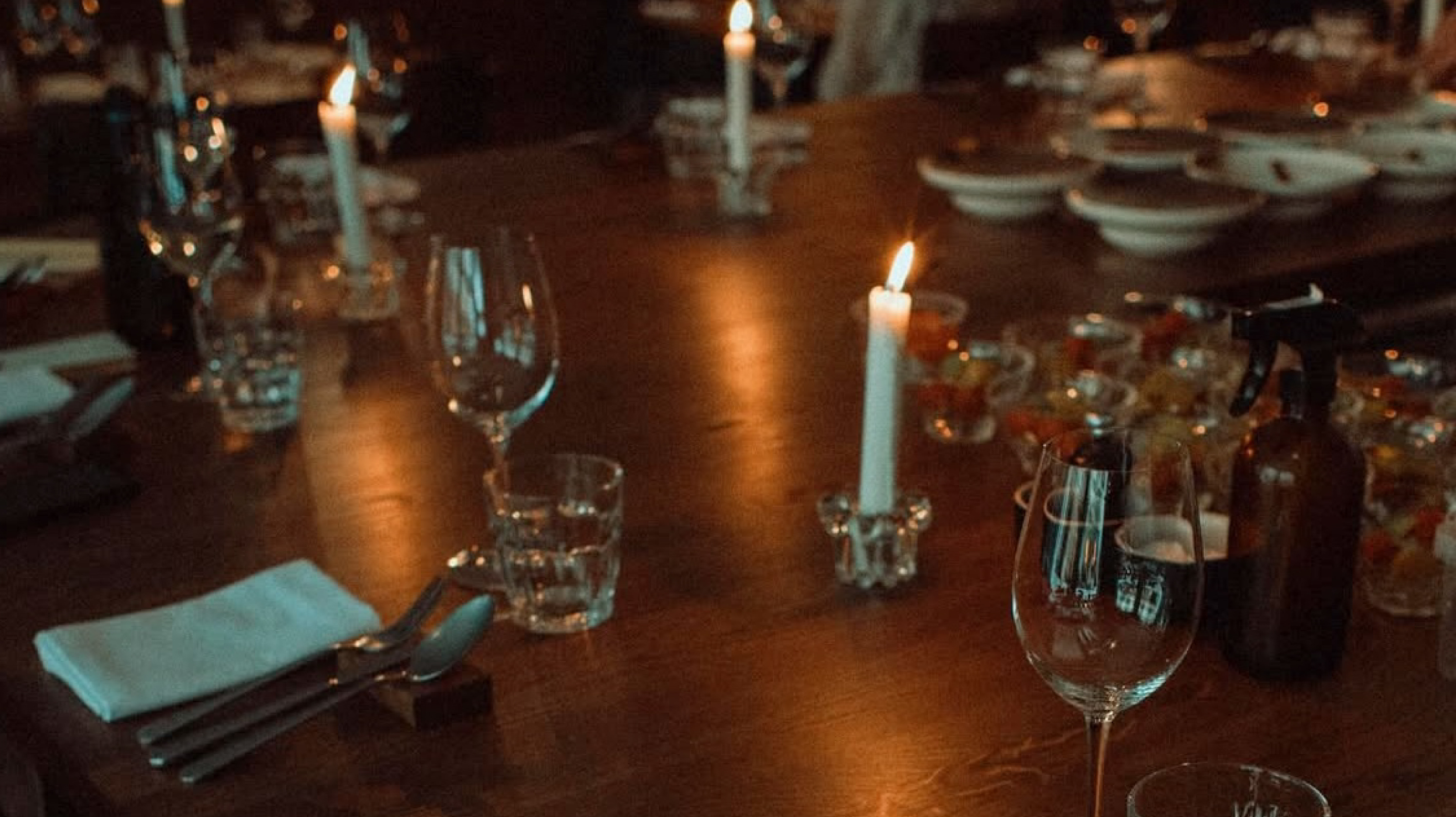 Candles and glasses on a set dinner table